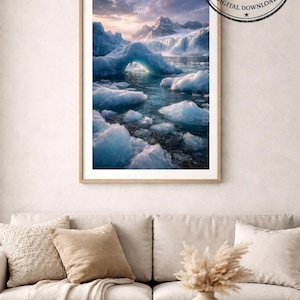 Op de afbeelding: Een ingelijste print van een gletsjerlandschap met ijsbergen en bergen. Het kunstwerk toont een serene scène met blauwe ijsformaties en een bewolkte lucht. De print wordt weergegeven boven een beige bank met decoratieve kussens en een houten salontafel.