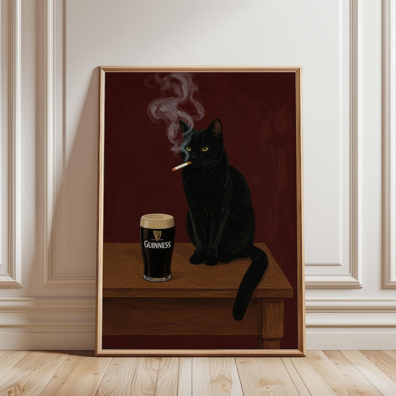 K&ouml;nnte beinhalten: Gerahmter Kunstdruck mit einer schwarzen Katze, die eine Zigarette raucht, mit einem Pint Guinness daneben. Die Katze sitzt auf einem Holztisch vor einem dunkelroten Hintergrund. Das Guinness-Glas zeigt das Markenlogo.
