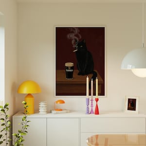 K&ouml;nnte beinhalten: Ein gerahmter Kunstdruck zeigt eine schwarze Katze, die eine Zigarette raucht, mit einem Pint Guinness auf einer Holzoberfl&auml;che. Der Hintergrund ist tiefrot. Der Druck wird &uuml;ber einem wei&szlig;en Schrank mit Kerzen und einem kleinen gerahmten Bild angezeigt.