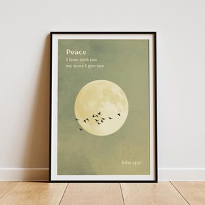Könnte beinhalten: Gerahmter Kunstdruck mit Vollmond und fliegenden Vögeln vor einem grün-gelben Hintergrund. Der Druck enthält das Wort "Frieden" und ein Zitat aus Johannes 14:27.