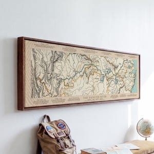 May include: A rectangular wall art print featuring a detailed topographical map of the Yangtze River in China, framed in dark wood. The map displays geographical features, river paths, and text labels including The Yangtze River title.