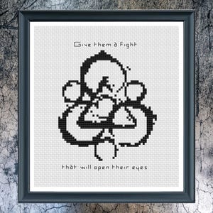 Può includere: Opera d'arte a punto croce incorniciata con un design geometrico nero su sfondo bianco. Il testo in alto recita "Give them a Fight" e in basso "That will open their eyes." La cornice è nera.