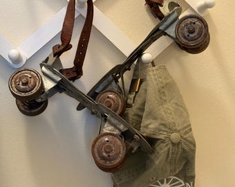 Patines de ruedas metálicos vintage con correas de cuero, sin marcas, de los años 50, oxidados.