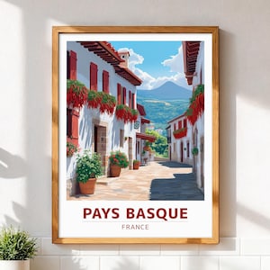 Puede incluir: Una impresión artística enmarcada que representa una pintoresca escena callejera en la región del País Vasco, Francia. La imagen muestra edificios blancos con contraventanas y jardineras rojas, una calle adoquinada y una montaña. El texto "PAYS BASQUE FRANCE" está en la parte inferior.