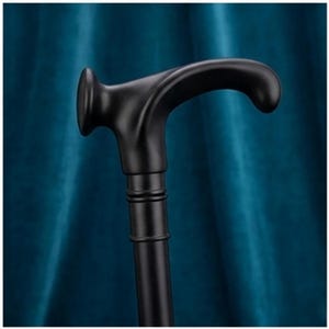 Könnte beinhalten: Ein mattschwarzer Gehstock mit einem geschwungenen, ergonomischen Griff und einer abgerundeten Endkappe. Der Schaft ist über eine glatte, zylindrische Manschette mit zwei horizontalen Ringdetails mit dem Griff verbunden, was ein schlichtes Design ergibt.