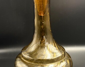 Decantador vintage de cristal Empoli color ámbar con forma de botella de genio, con diseño retorcido.