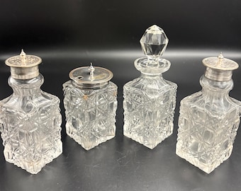Juego victoriano de cuatro piezas de aceiteras o condimentos de cristal tallado con tapas bañadas en plata.