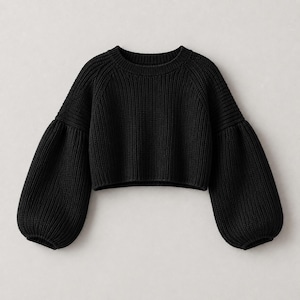 May include: A solid black cropped sweater featuring a ribbed knit texture, a round neckline, and voluminous raglan sleeves that taper into fitted ribbed cuffs. The garment has a straight hemline and a consistent knit pattern throughout.