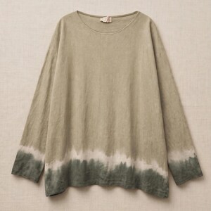 May include: A long-sleeve shirt in a muted sage green hue, featuring a round neckline and a dip-dye effect at the hem. The garment transitions from a light olive tone at the top to a darker forest green shade at the bottom with a white band.