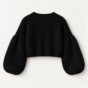 May include: A black long-sleeve sweater featuring a ribbed knit texture, a crew neckline, and voluminous balloon sleeves. The garment has a cropped length and a solid black color throughout, showcasing a consistent knit pattern.