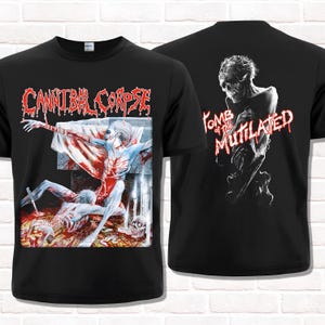 Puede incluir: Camisetas negras con diseños gráficos. Una camiseta muestra el nombre de la banda "Cannibal Corpse" en rojo, con una escena sangrienta. La otra camiseta muestra "Tomb of the Mutilated" en rojo, con una figura esquelética.