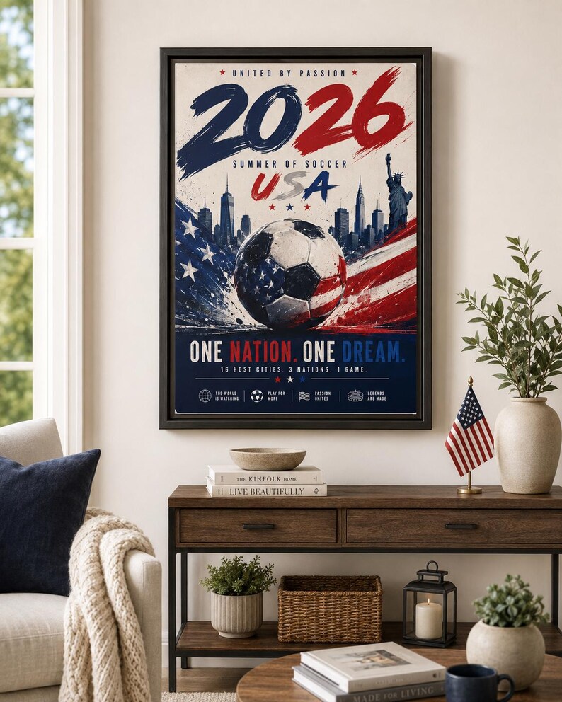 Puede incluir: Un p&oacute;ster enmarcado con el texto 2026 SUMMER OF SOCCER USA, UNITED BY PASSION y ONE NATION. ONE DREAM. El dise&ntilde;o incluye un bal&oacute;n de f&uacute;tbol con patrones de la bandera estadounidense, un horizonte urbano, la Estatua de la Libertad y colores rojo, blanco y azul.
