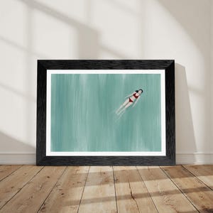 May include: A framed art print featuring a person in a red two-piece swimsuit floating in calm, light green water. The artwork is enclosed in a textured black frame, showcasing a serene scene with vertical brushstroke textures in the water.