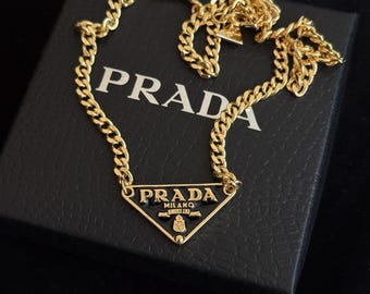 Colar Prada com Pingente Triangular, Joia Marcante em Dourado e Preto, Acessório Geométrico Minimalista