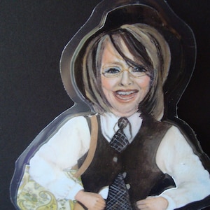 Puede incluir: Una ilustración de acuarela de una persona que lleva un chaleco negro, una camisa blanca y una corbata con estampado en blanco y negro. La persona sostiene una guitarra y lleva una bolsa con estampado paisley.