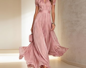 May include: A dusty rose maxi dress featuring short puff sleeves, a high neckline with a keyhole cutout, and a fitted waistline. The skirt is floor-length with a flowing, pleated design, crafted from a smooth, satin-like fabric with a subtle sheen.