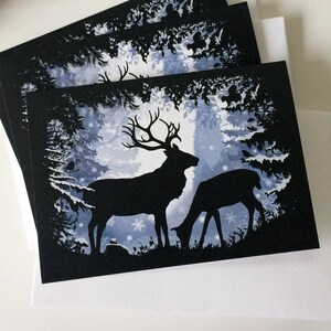 Forêt d'hiver avec des cerfs Carte de voeux saisonnière illustrée Noir, blanc, silhouette bleue, cerf, biche, rouges-gorges, arbres, flocons de neige, blanc à l'intérieur