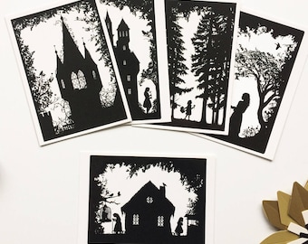 May include: A collection of five black and white silhouette art prints. The prints depict scenes of castles, forests, and figures, all framed by intricate border designs. The art prints are arranged on a white surface.