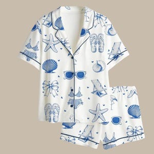 Puede incluir: Una taza de cerámica blanca con un asa negra y el texto "But First, Coffee" en negrita negra. La taza se encuentra sobre un fondo borroso, sugiriendo un ambiente acogedor.