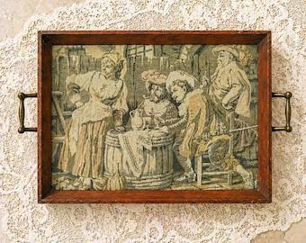 Bandeja de servir de madera antigua con inserto de tapiz y asas de latón. Arte con escena de taberna flamenca.