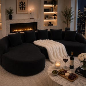 May include: A contemporary black sectional sofa with soft cushions and a curved shape. A white faux fur throw is draped over the sofa. A marble coffee table displays a wine bottle, glasses, and a candle.
