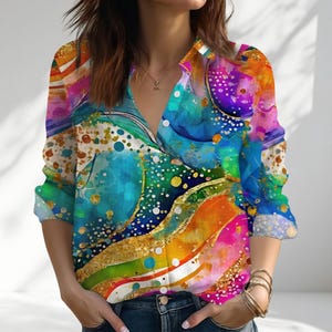 May include: A long-sleeved button-down shirt with a vibrant abstract design. The shirt features a colorful pattern with shades of blue, green, orange, and pink, accented with gold details. The shirt has a V-neck collar and is made of a lightweight fabric.