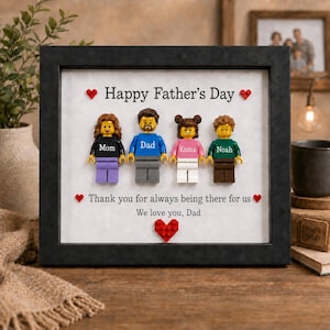 Może przedstawiać: Oprawiony prezent na Dzień Ojca z figurkami Lego przedstawiającymi rodzinę. Ramka zawiera tekst "Happy Father's Day", "Thank you for always being there for us" i "We love you, Dad."