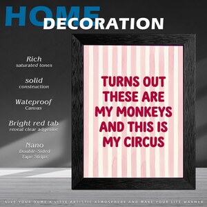 May include: A framed wall art print with a black frame. The print has a pink and white striped background with the text "TURNS OUT THESE ARE MY MONKEYS AND THIS IS MY CIRCUS" in red. The image is for home decoration.