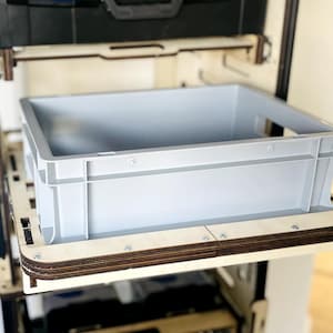 Könnte beinhalten: Ein Set aus drei Keramikbechern mit gesprenkelter, matter Oberfläche. Die Becher sind in Creme-, Hellgrau- und Dunkelgrautönen gehalten. Jeder Becher hat ein schlichtes, minimalistisches Design und einen abgerundeten Henkel.