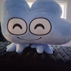 May include: A light blue plush toy shaped like the number four, featuring a soft, fuzzy texture. The character has two large, circular white eyes with black outlines and curved black lines for pupils, along with a thin, curved black line for a mouth.