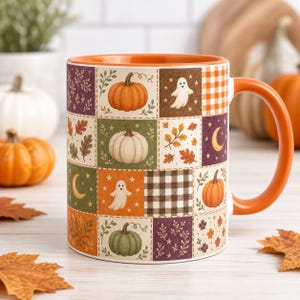 May include: A ceramic mug with an orange handle and interior, featuring a patchwork grid design of autumn-themed illustrations including pumpkins, ghosts, crescent moons, fall leaves, and black and white buffalo check patterns on a cream background.