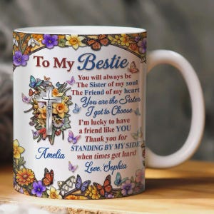 May include: A white ceramic mug featuring a colorful floral and butterfly border. The text reads: To My Bestie, You will always be the Sister of my soul, The Friend of my heart, You are the Sister I got to Choose, Amelia, Love, Sophia.