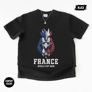 May include: Black t-shirt featuring a stylized rooster design in the colors of the French flag: blue, white, and red. The text "FRANCE WORLD CUP 2026" is printed below the rooster. The shirt has a crew neck and short sleeves.