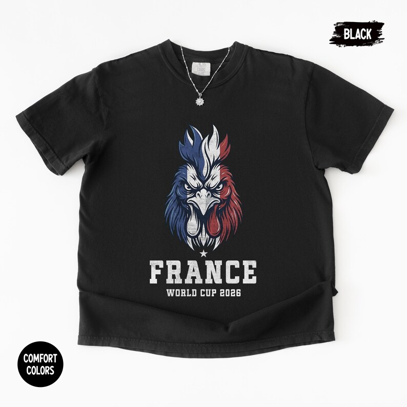 May include: Black t-shirt featuring a stylized rooster design in the colors of the French flag: blue, white, and red. The text "FRANCE WORLD CUP 2026" is printed below the rooster. The shirt has a crew neck and short sleeves.