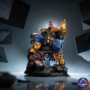 Pode incluir: Uma estátua detalhada de Thanos, sentado em um trono. A figura é predominantemente azul e dourada, com um rosto roxo e a Manopla do Infinito dourada. O trono é vermelho e dourado, sobre uma base rochosa. Um item colecionável.