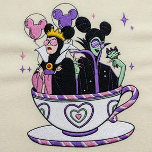 May include: Embroidered design featuring two cartoon villains in a teacup, wearing sunglasses and holding Mickey Mouse balloons. The teacup is white with purple and pink accents, and the background is a cream color. The villains are wearing black and purple outfits.