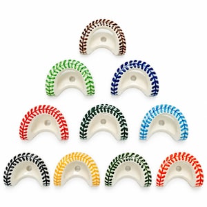 May include: Ten semi-circular ceramic chopstick rests arranged in a pyramid. Each white piece features a hand-painted baseball-style stitch pattern along the curved edge in various colors: brown, green, blue, red, dark green, light blue, black, yellow, olive, and orange.
