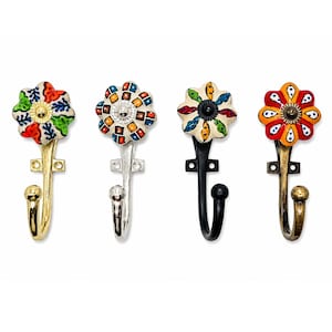 May include: Four wall hooks featuring decorative ceramic flower-shaped knobs with colourful hand-painted patterns. Each hook has a distinct metal finish, including polished gold, silver, matte black, and antique brass, with a ball-tipped end.