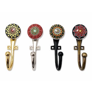 Può includere: Quattro ganci da parete con pomelli decorativi rotondi dipinti a mano, caratterizzati da intricati motivi a pois in giallo, rosso, verde e nero. Ogni gancio presenta una finitura metallica distinta: oro lucido, argento, nero opaco e bronzo antico.