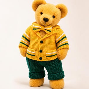 Può includere: Un orsacchiotto di peluche dal pelo marrone dorato che indossa un cardigan in maglia giallo con polsini e orlo a righe verdi e bianche, un papillon abbinato e pantaloni in maglia verde scuro. Il cardigan presenta tre bottoni neri e due tasche.