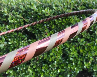 May include: A copper-colored hoop with a green and brown striped tape. The tape has a glittery finish.