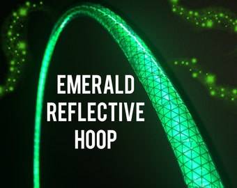 May include: Emerald reflective hoop with a geometric pattern, glowing brightly against a dark background. The text "EMERALD REFLECTIVE HOOP" is displayed in white, highlighting the product's features.