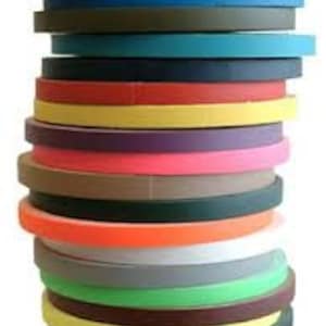 May include: A stack of 20 rolls of colourful duct tape. The tape is 2.5 cm wide and comes in a variety of colours, including red, blue, green, yellow, orange, purple, brown, black, and white.