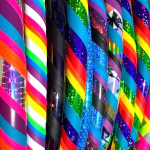 Peut inclure: Gros plan sur une variété de cerceaux colorés. Les cerceaux sont faits de différents matériaux, dont le plastique, le métal et le tissu. Ils sont décorés de rayures, de paillettes et d'autres motifs.