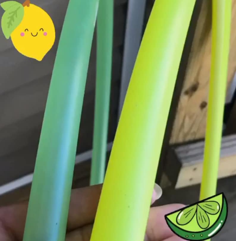 May include: Two plastic hula hoops, one green and one yellow, are shown side-by-side. The hoops are both slightly translucent.