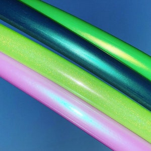 May include: Four hooping hoops in different colours: green, teal, light green, and pink. The hoops have a sparkly finish.