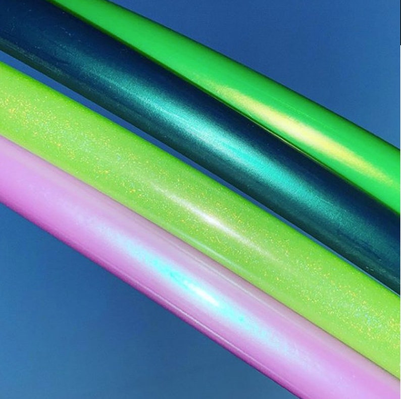May include: Four hooping hoops in different colours: green, teal, light green, and pink. The hoops have a sparkly finish.
