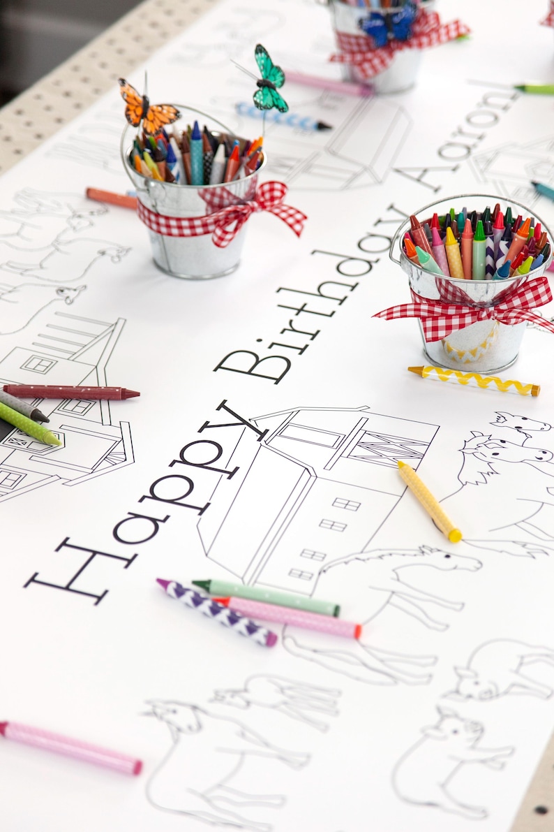My personalized farm themed coloring tablecloth features horses, cows, pigs, sheep, chickens, ducks, and various barns and tractors. It's staged here with mini tin milk buckets filled with crayons and adorned with red and white gingham ribbons.