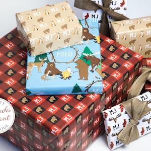 May include: Assortment of gift wrap featuring woodland animal designs. The wrapping paper is in a variety of colors and patterns, including red, blue, brown, and white. The wrapping paper is decorated with bears, deer, and other woodland animals. The wrapping paper is also decorated with the letters "MJ" and "MILO".