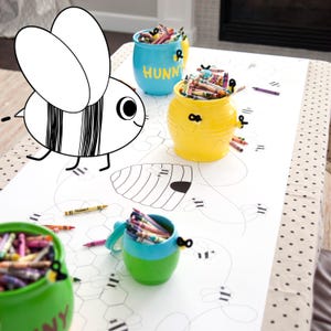 A table is set for a bee themed party or baby shower. A table length coloring page is laid over a dotted tablecloth. The design features happy bees, honeycombs, and a hive in the center. Optional text runs lengthwise along the edges. There are brightly painted honey jars filled with crayons on the table. This listing is for the coloring table runner only.
